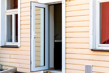 Fototapeta na wymiar Horizontal shot of glass front door of an upscale home with windows/Exterior shot of an open old glass Door