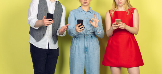 Group of friends using mobile smartphones. Teenagers addiction to new technology trends. Close up. Millenials texting, scrolling, chatting, watching video or shopping online. Connecting with devices.