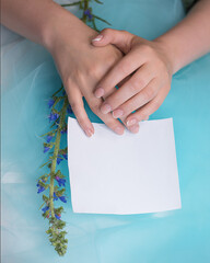 beautiful female hands with perfect French manicure and piony hold a piece of paper. Copyspace. A great opportunity to promote an advertising campaign on your website or in social networks