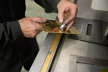Close up of hands working with metal component in factory
