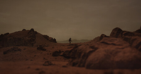 Lonely astronaut walking on a surface of a red rocky planet. Mars colonization concept. Planet created in 3D © supamotion