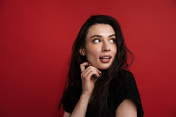 Photo of brunette young woman in casual t-shirt posing and looking aside