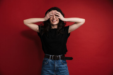 Photo of cheerful woman in casual t-shirt laughing and covering her face