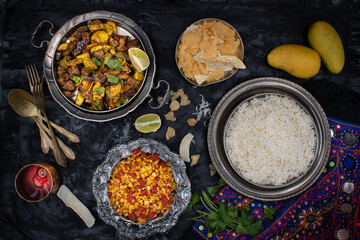 Vegan Indian dishes served in exotic bowls on dark table