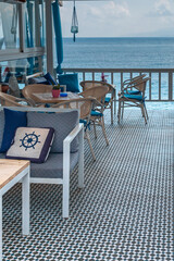 chairs and a table a coastal cafe on the Mediterranean coast in the recreation area of ​​the Greek city of Hersonissos during quarantine COVID-19