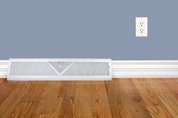 Bedroom wall with heating register, baseboard, electrical outlet and hardwood floor.