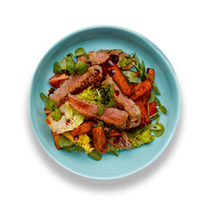A delicious bowl of BBQ rump steak strips, sweet potatoe chips and vegetables, in a light blue bowl isolated on white background