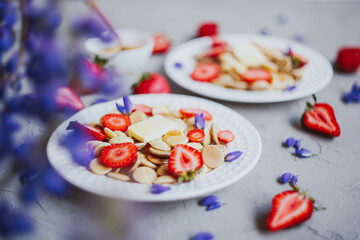 Pancake cereal, trendy food. Mini cereal pancakes with butter, honey, and strawberries.