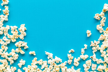 Popcorn frame on blue background top view copy space