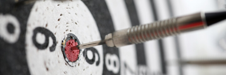 Dart shot to bull eye of dartboard among others