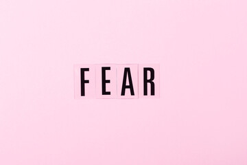 Letters FEAR onthe pink background. Negative emotions concept.