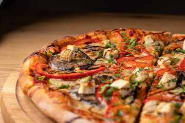 Big pizza with tomatoes, cheese, meat and red pepper. Delicious Italian national cuisine. High-calorie dinner for the whole family.