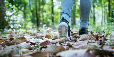 sneaker shoes young woman traveler sit down on summer park. Focus on sneaker shoes and jeans on pathway in forest park. active activity vacation on hike mountain walking way. Young traveler concept