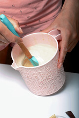 A woman mixes the dough with a spatula. For the preparation of biscuit roll with spinach and mint. Stuffed with strawberries. Ingredients for cooking.