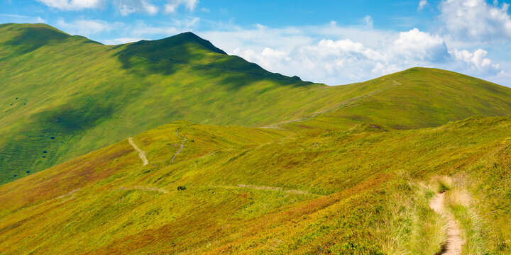 trail uphill through mountain range. grass on the hills and slopes. summer landscape on a sunny day.