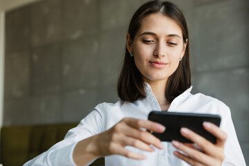 Attractive smiling young lovely brunette woman watching video