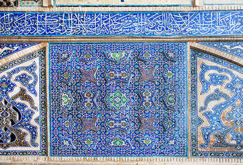Traditional tiles with Persian patterns on wall of historical mosque. Iran.
