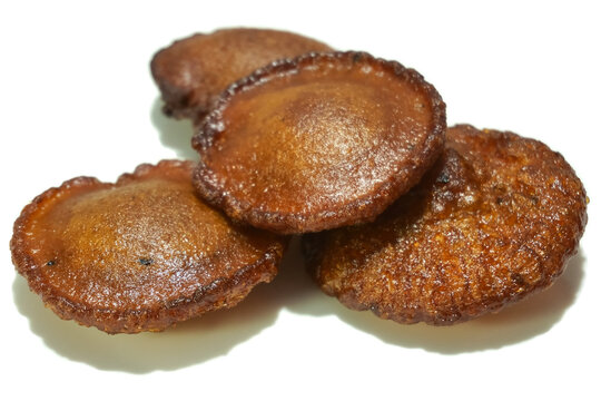 Traditional sweet snack from Kerala called Neyyappam isolated on a white background. It's made of rice flour, ghee, jaggery, coconut and cardamom.