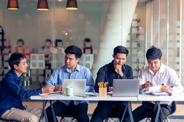 Meeting of young asian business people who are committed to work. Creative business team sitting working together at office.