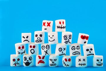 Marshmallows close-up and copy space on blue background. Marshmallows for Halloween emoticons.
