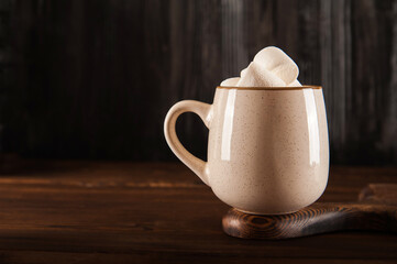 Concept with marshmallows in a circle on a dark background. Autumn, coffee, tea, mug, marshmallows, cozy. Fall concept closeup and copy space on dark background.