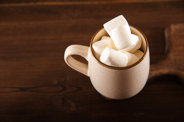 Concept with marshmallows in a circle on a dark background. Autumn, coffee, tea, mug, marshmallows, cozy. Fall concept closeup and copy space on dark background.