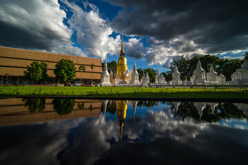 Fototapeta na wymiar Wat Suan Dok Temple with rain clouds and reflection, is a Buddhist temple and Royal Temple of the Third Class in Chiang Mai Thailand. Landmark of Chiang mai..