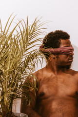 portrait of a young black man with eyes covered