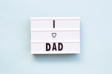 'I love dad' words on a lightbox over blue background, top view. Overhead, from above, flat lay.