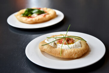 pizza fritta fried pizza typical of the Campania region in southern Italy with salmon and burrata cheese on a black background