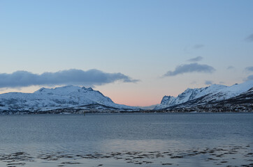 Fototapeta na wymiar snow covered mountains and sunset over fjord