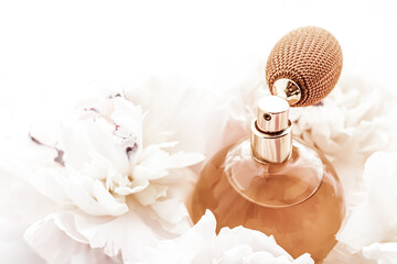 Fragrance bottle as vintage perfume product on background of peony flowers, parfum ad and beauty...