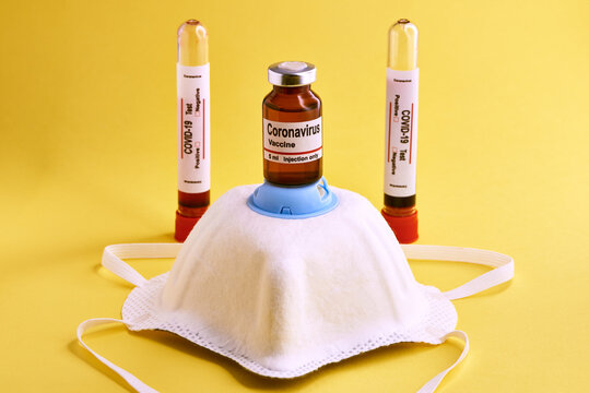 Medical set with coronavirus vaccine placed with respirator mask and test tubes with blood samples on yellow background