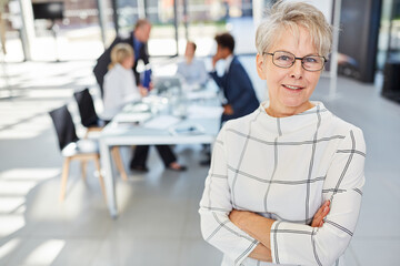 Senior woman as a confident boss in front of her team