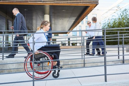 Woman in a wheelchair on her way to work on ramp