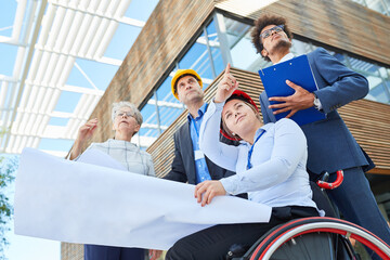 Architect in a wheelchair and engineers as a team