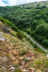 Fototapeta na wymiar View down to section of Cliff Road which winds through the cheddar gorge rock faces and steep cliffs near Bristol in North Somerset