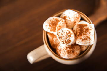 Concept with marshmallows in a circle on a dark background. Autumn, coffee, tea, mug, marshmallows, cozy. Fall concept closeup and copy space on dark background.