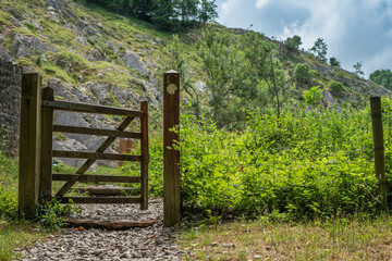 Fototapeta na wymiar Footpath entrance gate near Rock of Ages at the Cheddar Gorge. Cliffs seen in the background.