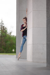 Girl ballerina in jeans, a plaid shirt and pointe shoes dancing in the city on the street © Tatiana
