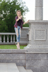 Girl ballerina in jeans, a plaid shirt and pointe shoes dancing in the city on the street © Tatiana