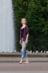 Girl ballerina in jeans, a plaid shirt and pointe shoes dancing in the city on the street © Tatiana