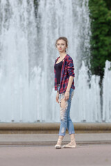 Girl ballerina in jeans, a plaid shirt and pointe shoes dancing in the city on the street © Tatiana