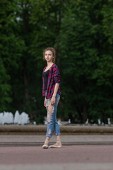 Girl ballerina in jeans, a plaid shirt and pointe shoes dancing in the city on the street © Tatiana