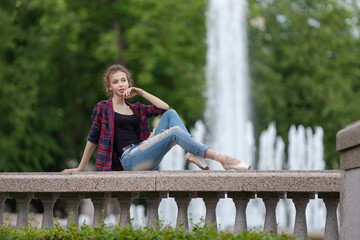 Girl ballerina in jeans, a plaid shirt and pointe shoes dancing in the city on the street © Tatiana