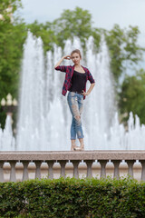 Girl ballerina in jeans, a plaid shirt and pointe shoes dancing in the city on the street © Tatiana