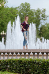 Girl ballerina in jeans, a plaid shirt and pointe shoes dancing in the city on the street © Tatiana