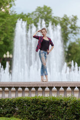 Girl ballerina in jeans, a plaid shirt and pointe shoes dancing in the city on the street © Tatiana