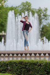 Girl ballerina in jeans, a plaid shirt and pointe shoes dancing in the city on the street © Tatiana