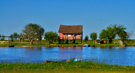 Fototapeta na wymiar Colorful landscape of rural house on island on river bank.